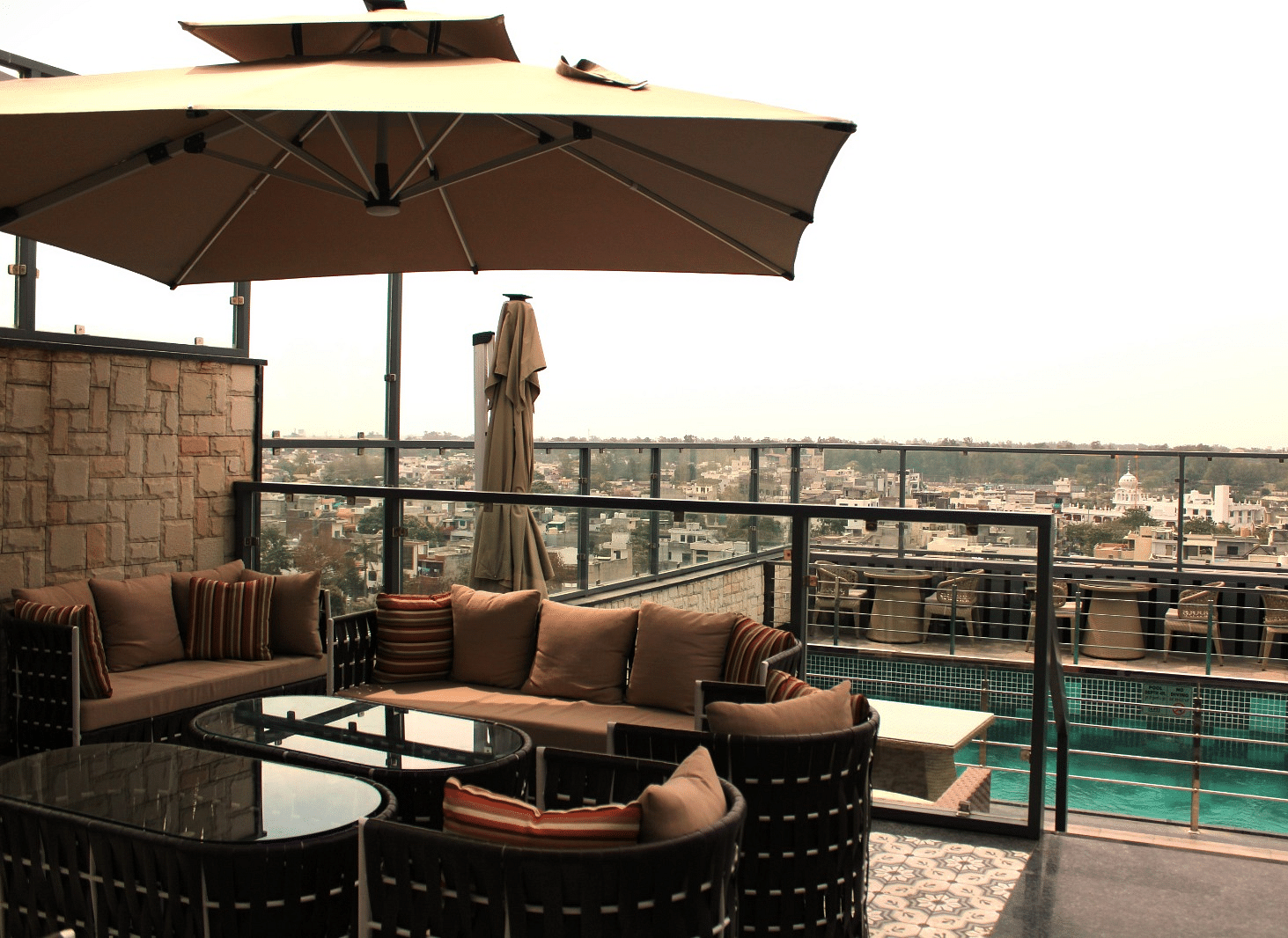 A rooftop lounge with a spacious patio and an adjacent swimming pool at BluSalzz Residence, Amritsar